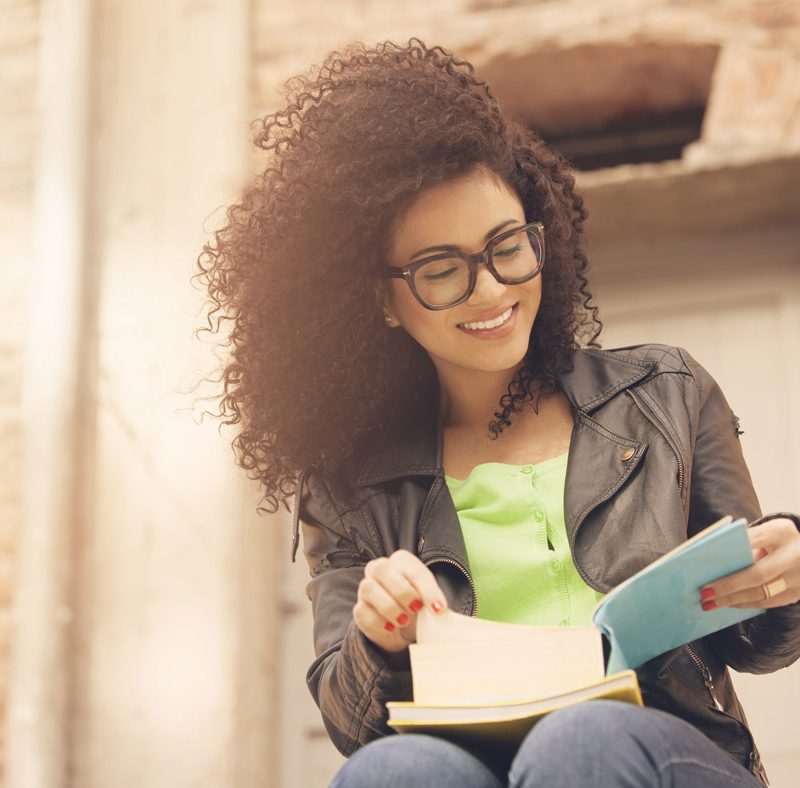 Image of woman smiling, reading book.